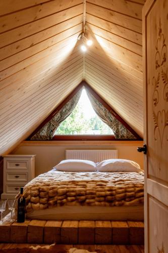 a bed in a room with a triangular window at Apartament Górski u Papierzy Sauna, Jacuzzi, SPA in Witów