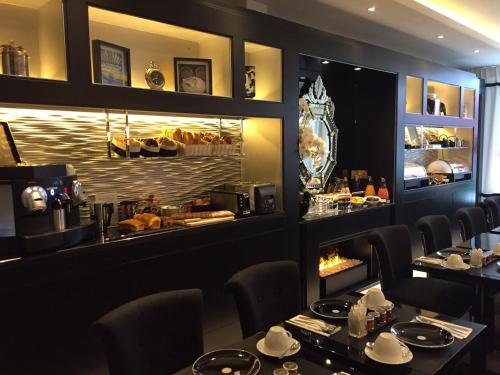 un restaurant avec deux tables et un comptoir de nourriture dans l'établissement Petit Madeleine Hôtel, à Paris
