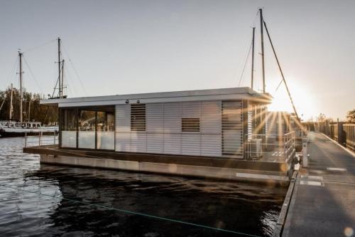 een huis op een boot in het water bij Hausboot freiZeit - LP4 in Peenemünde