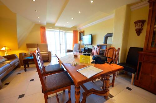 un soggiorno con tavolo e sedie in legno di Sonnenkliff OG a Groß Zicker