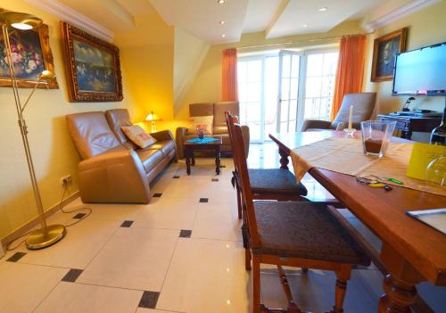 un soggiorno con tavolo da pranzo e divano di Sonnenkliff OG a Groß Zicker