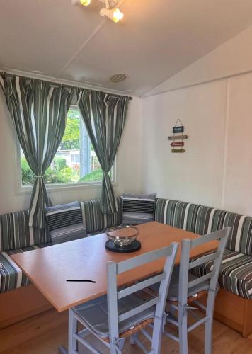 un salon avec une table et un canapé dans l'établissement Mobilhome, à Saint-Paulet-de-Caisson