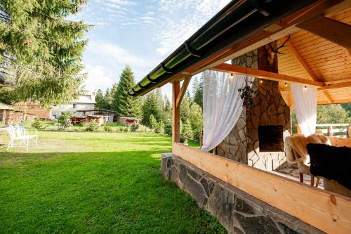a stone building with a gazebo in a yard at Apartament Górski u Papierzy Sauna, Jacuzzi, SPA in Witów