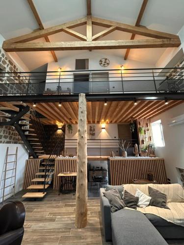 Ce loft comprend un escalier et un canapé. dans l'établissement La Petite Chavanne 4 étoiles, à Champdieu