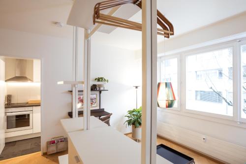 a white room with a loft bed and a window at Boutique Apartment im trendigen Quartier am Rhein in Basel