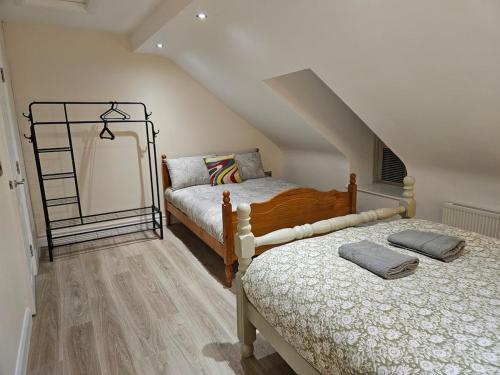 a bedroom with two beds and a staircase at Forthill Lodge in Enniskillen