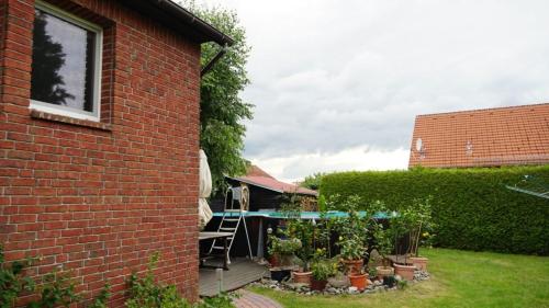a garden with plants in pots on a patio at Pension Limone Ferienwohnung 2 in Neu Lindenberg
