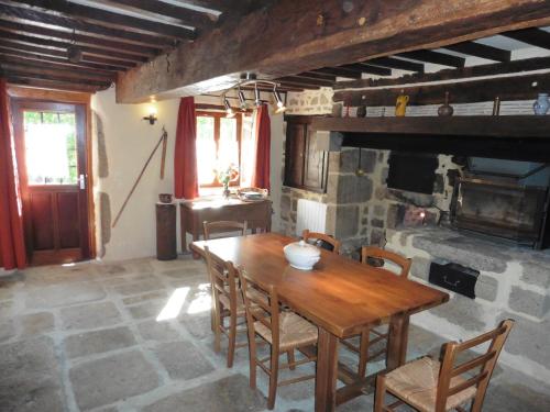 a dining room with a wooden table and chairs at la maison de Voueize in Peyrat-la-Nonière