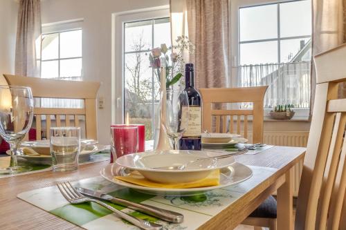 una mesa de comedor con un plato y una botella de vino en Stürmann, en Prerow