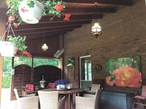 a patio with a table and chairs and a fireplace at Ferienhaus beim Rosengarten in Holthaus