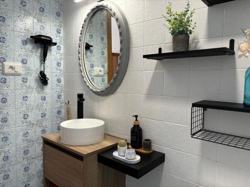 a bathroom with a sink and a mirror at Parking Privado l Terraza Relajante Junto Al Mar in Tavernes de Valldigna