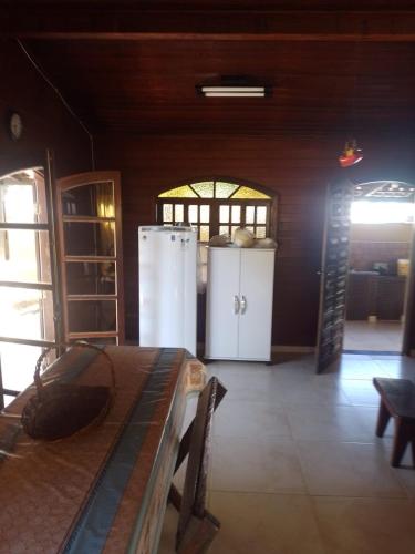 a kitchen with a refrigerator and a table in a room at Casa de Praia Aconchegante in Bertioga
