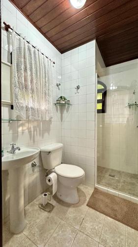 a bathroom with a toilet and a sink and a shower at Janela dos Meus Sonhos in Penedo