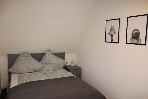 a bedroom with a bed with four pictures on the wall at Ferienhaus Strandnah - Wohnung 2 in Otterndorf