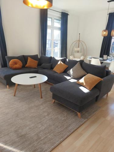 a living room with a blue couch and a table at maremar - 116qm mit 2 Schlafzimmern - Perfekt für Familien - Holzmarkt - Luxus Boxspringbetten - Küche - Balkon - Arbeitsplätze in Verden