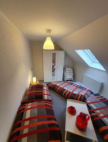 a attic room with two beds and a window at Ferienwohnung an der Mosel, Romeo in Senheim