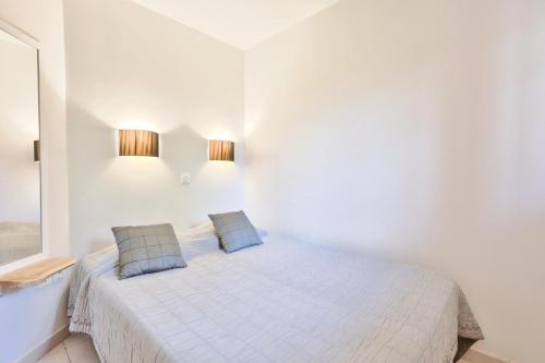- une chambre blanche avec un lit et deux oreillers dans l'établissement Résidence La Pinède - maeva Home - Appartement 2 pièces 4 personnes vue Mer - Sélection MAE-4181, à Hyères