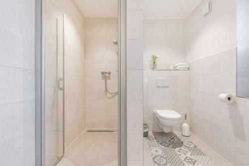ein weißes Badezimmer mit Dusche und Toilette in der Unterkunft Ferienhof Marquardt Bungalow 2 in Fehmarn