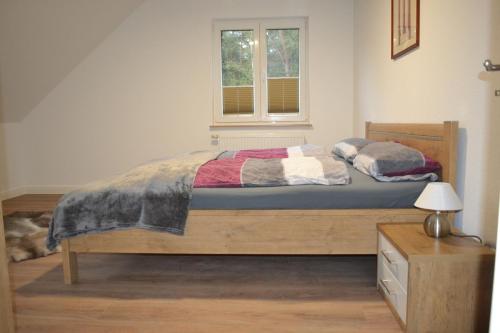 a bedroom with a wooden bed with a window at Ferienhof Thele Wohnung OG in Werlte