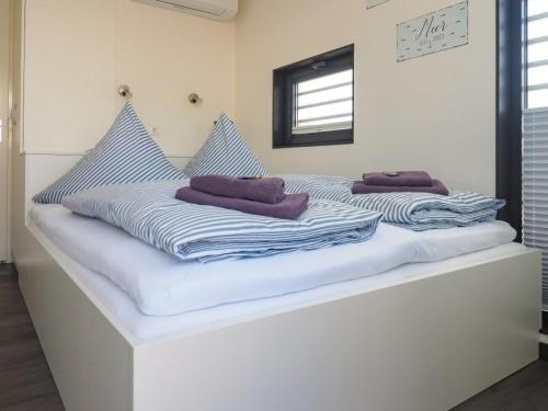 a white bed with towels on top of it at Hausboot Krosse Krabbe - LP6 in Peenemünde