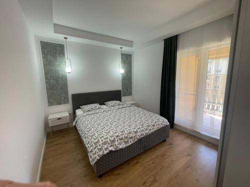 a bedroom with a bed and two windows at Sedi Royal Cosmopolis in Ştefăneştii de Sus