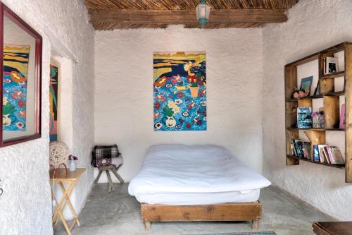 a bedroom with a bed and a painting on the wall at Casa Sulahue in Real de Catorce