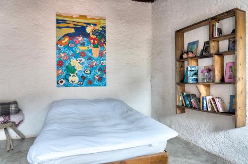 a bedroom with a bed and a painting on the wall at Casa Sulahue in Real de Catorce