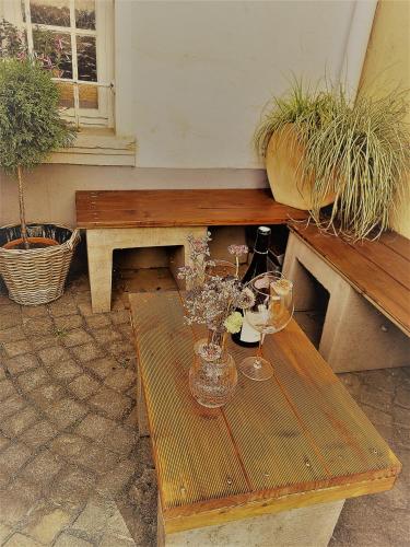 a wooden table with two glasses and a vase of flowers at Ferienwohnung Villa Wolke in Sankt Wendel