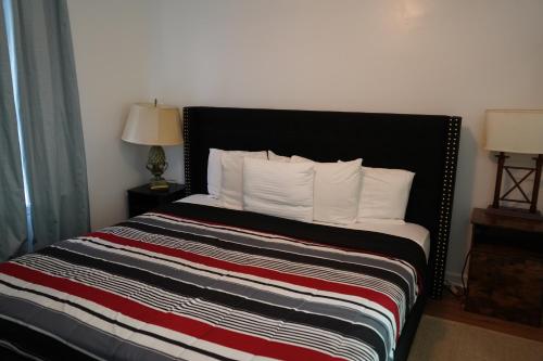 a bed with a black headboard and white pillows at Cozy Bartlett home with garage, fenced backyard in Memphis