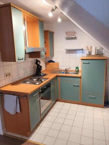 a kitchen with blue cabinets and a stove top oven at Ferienwohnung Villa Wolke in Sankt Wendel