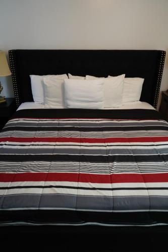 a bed with a red white and blue striped blanket at Cozy Bartlett home with garage, fenced backyard in Memphis