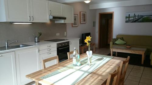 a kitchen with a wooden table and a kitchen with a sink at Ferienhof Kruse Wohnung 8 in Grömitz