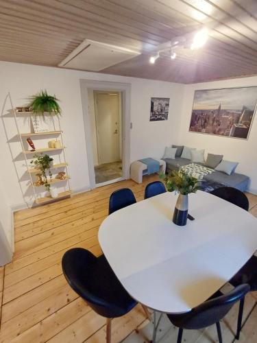 a living room with a white table and chairs at Calm and cozy apartment with free parking in Hjørring