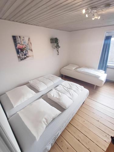 a bedroom with two beds in a room at Calm and cozy apartment with free parking in Hjørring