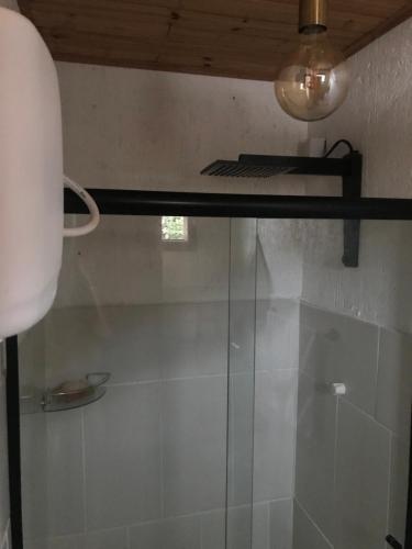 a shower with a glass door in a bathroom at Casa Jasmim in Imbituba