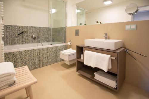 a bathroom with a sink and a toilet and a mirror at Apartment "Ostseeluft" in Prora