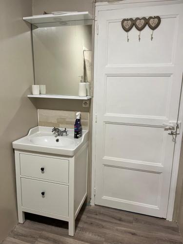 a bathroom with a white door and a sink at Fair Field in Sourdeval