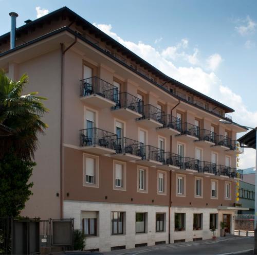 an apartment building with balconies on a street at Hotel Boston in Stresa