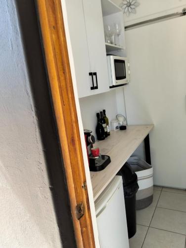 a small kitchen with a counter and a microwave at 57 on Milner in Kimberley