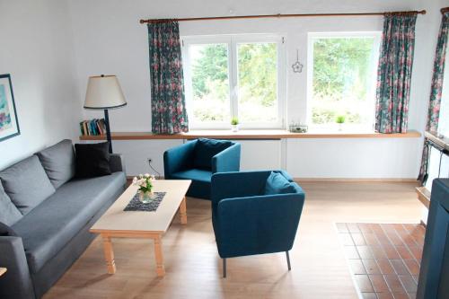 a living room with a couch and two chairs and a table at Landhaus Seeblick in Bitburg