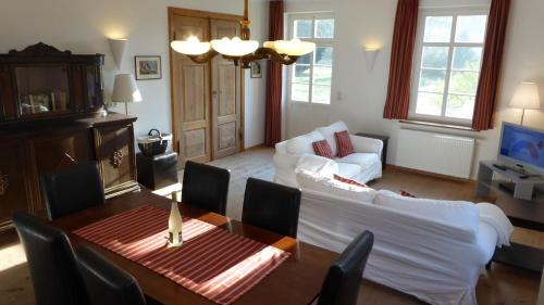 a living room with a table and a couch at Gut Rattelvitz, Parterre C WEST in Gingst