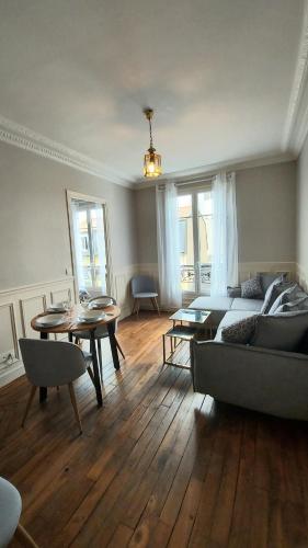 un salon avec un canapé et une table dans l'établissement La Garenne Colombes appartement, à La Garenne-Colombes