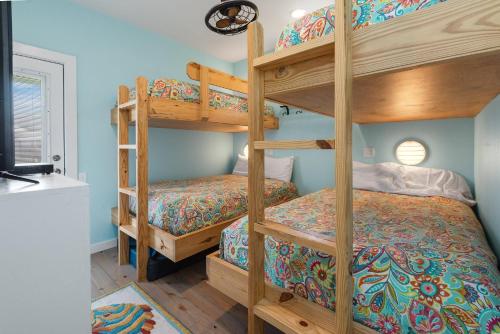 Cette chambre avec lits superposés comprend deux lits superposés et un lit superposé. dans l'établissement Mermaid Cove PA - Beach Gear Credit Included, à Fresno