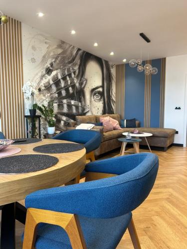 a room with blue chairs and a painting on the wall at Blue Iris, 2BR, Stunning Views, Jacuzzi and Workspace in Sofia