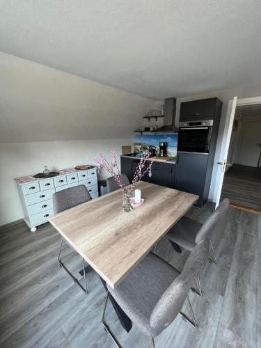 una cucina con tavolo e sedie in legno di Ferienwohnung Glück a Böhl