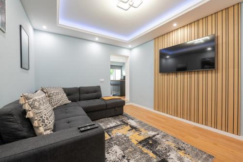 a living room with a couch and a tv on a wall at Madeira House by Mathias in Funchal