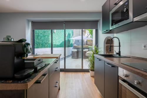 a kitchen with a large sliding glass door to a patio at Madeira House by Mathias in Funchal