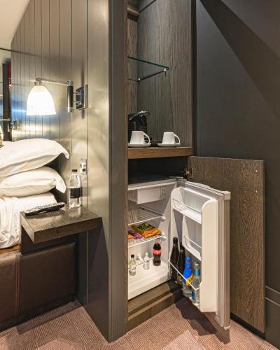a room with an open refrigerator next to a bed at Dakota Eurocentral in Motherwell