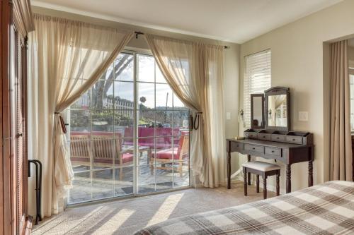 a bedroom with a bed and a desk and a balcony at Luxury Wine Country Haven Vineyard Views Near Top Wineries Adelaida Farmhouse in Paso Robles