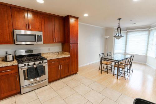 a kitchen with a stove and a table with chairs at Affordable Dorm Daly City in Daly City